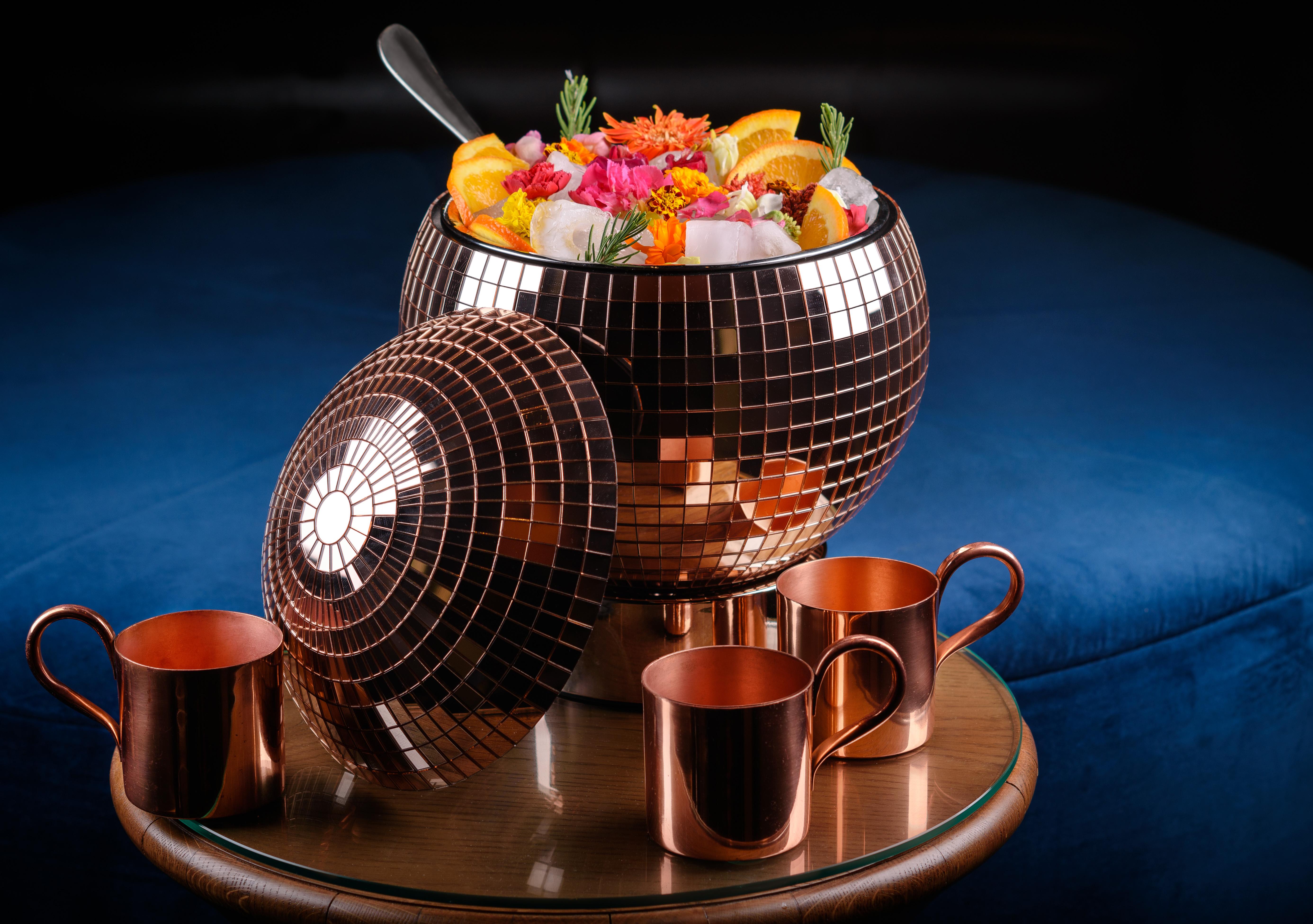 Hotel The Palazzo at The Venetian® Las Vegas Esterno foto The photo shows a large, brown, disco-ball-shaped bowl filled with colorful fruits, flowers, and ice. The bowl is shiny and reflective, resembling a disco ball. Surrounding the bowl are four copper cups, which are placed on a round wooden table. The 