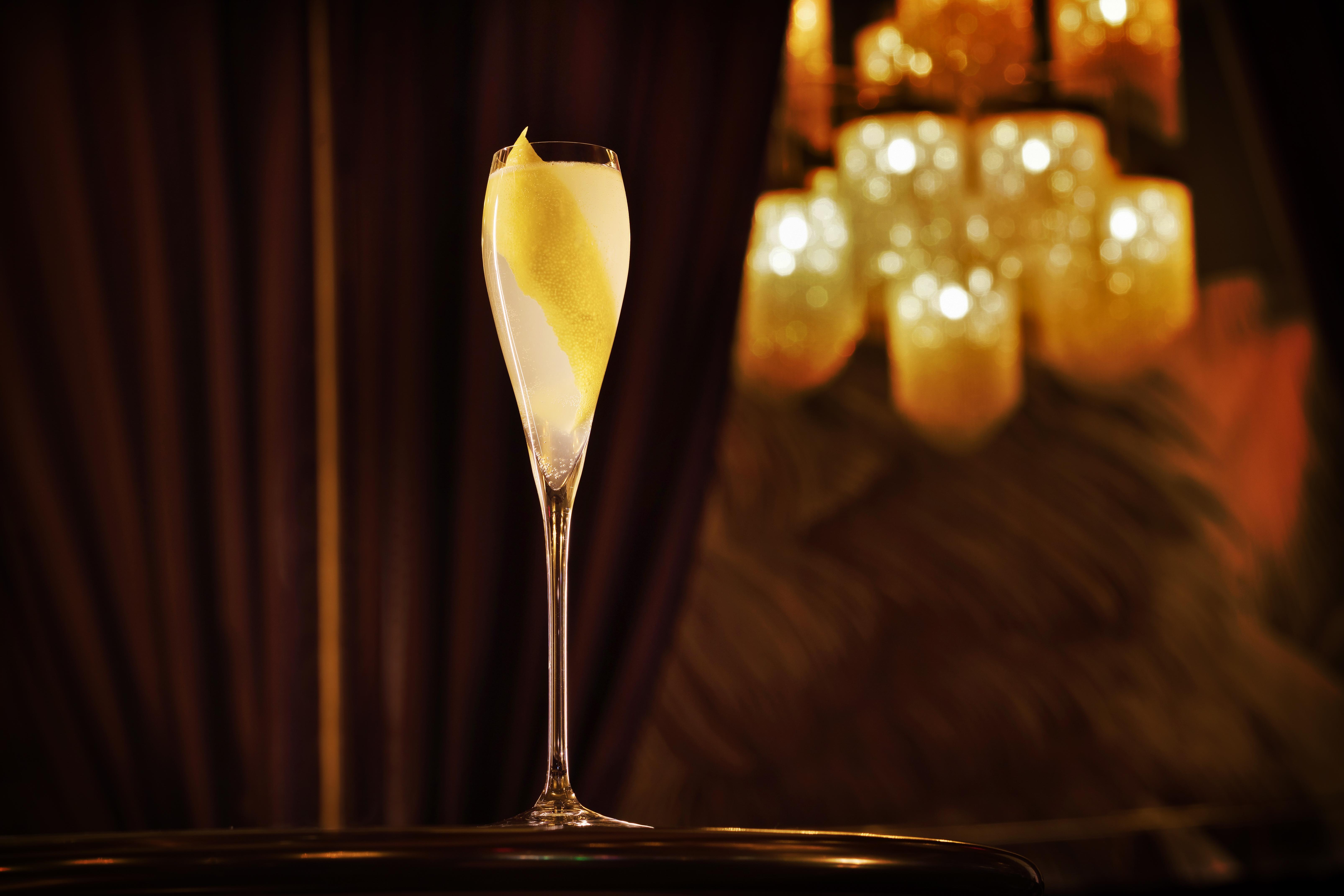 Hotel The Palazzo at The Venetian® Las Vegas Esterno foto The photo shows an elegantly arranged champagne flute filled with a light-colored beverage, possibly a cocktail or sparkling wine, featuring a twist of lemon peel as garnish. The glass is set against a backdrop of soft, warm lighting from a chandelie