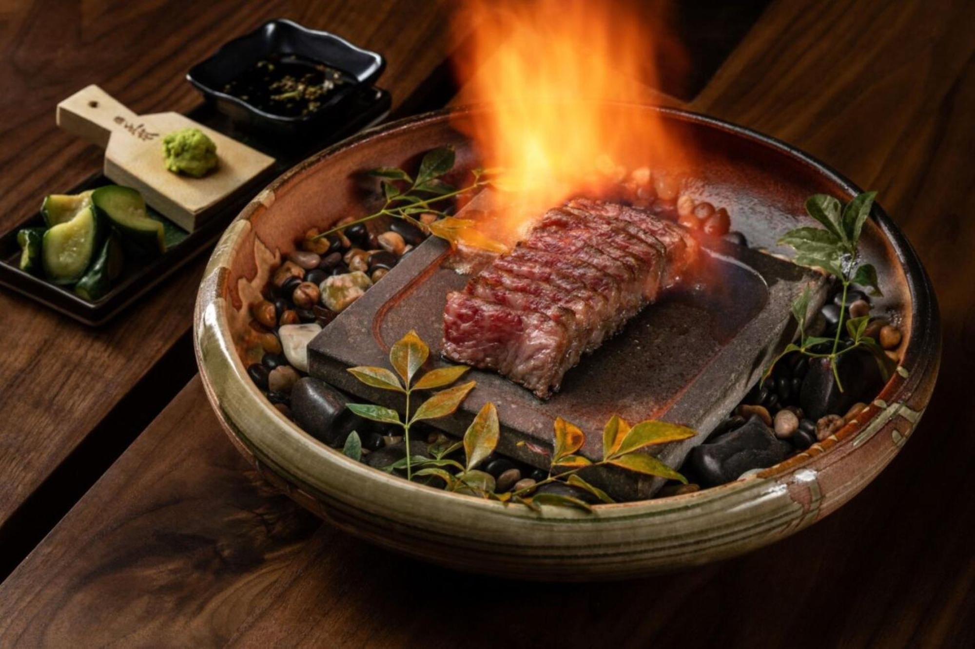 Hotel The Palazzo at The Venetian® Las Vegas Esterno foto The photo showcases a beautifully presented dish featuring a large cut of steak, which is placed on a hot stone that is surrounded by decorative elements such as small pebbles and greenery. The steak is ablaze, creating a dramatic visual effect with 
