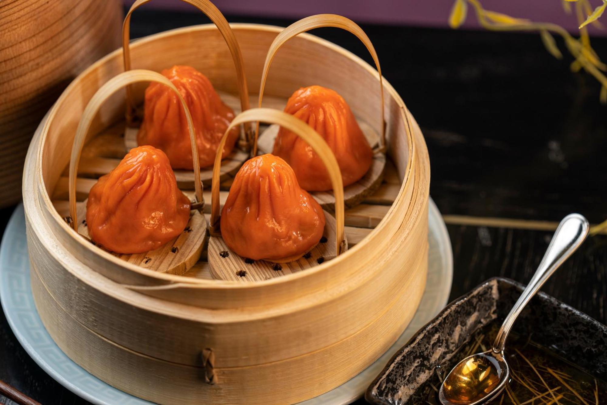 Hotel The Palazzo at The Venetian® Las Vegas Esterno foto The photo shows a bamboo steamer containing several dumplings, which appear to be a vibrant orange color. The dumplings are shaped like small pouches with a slightly pleated top, and they are held in place by bamboo strips. The steamer is resting on 