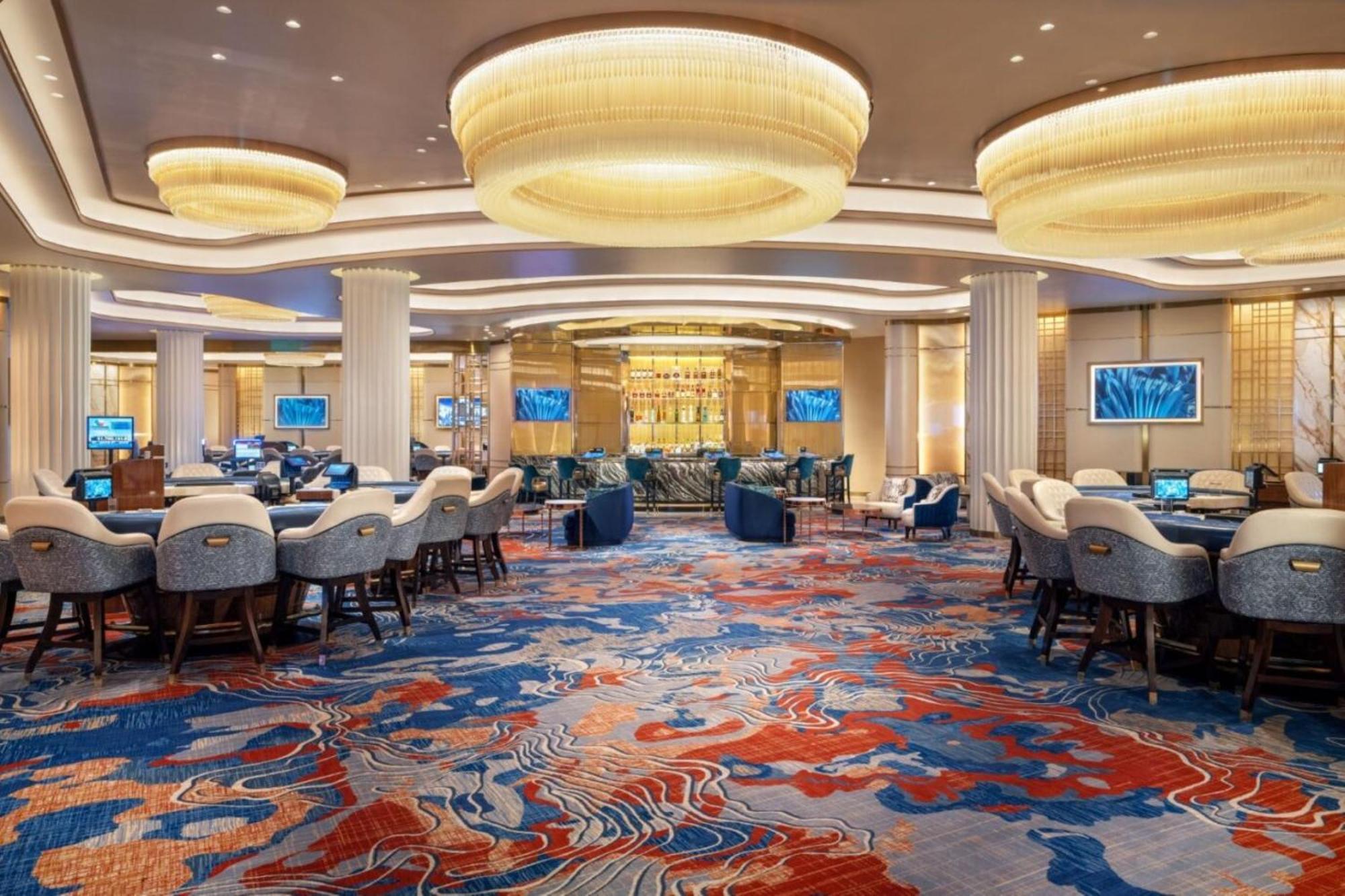 Hotel The Palazzo at The Venetian® Las Vegas Esterno foto The photo shows an elegant interior of a casino or gaming area. The space features a variety of seating arrangements, with comfortable chairs and tables for gambling activities. The flooring is adorned with a colorful, abstract carpet design primaril
